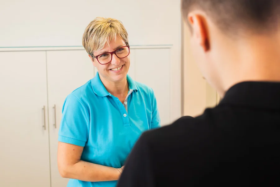 Freundliches Gespräch zwischen einer Mitarbeiterin und einem Patienten