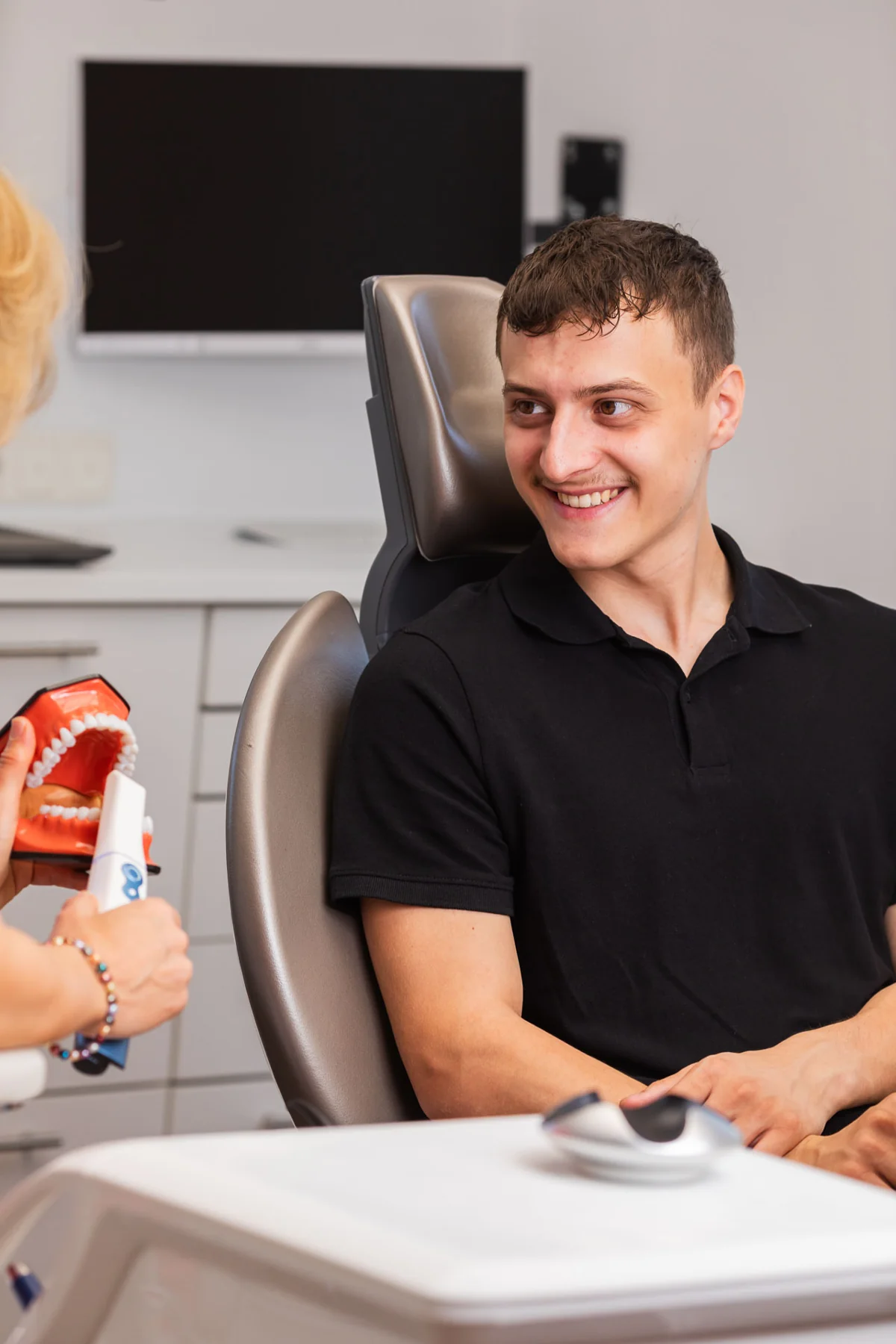 Patient im Behandlungsstuhl beim persönlichen Gespräch über die Behandlung